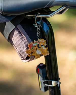 Keychain with cartoon characters attached to a bicycle seat post.