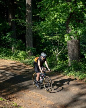 Person riding a recumbent bike on a trail in a forest